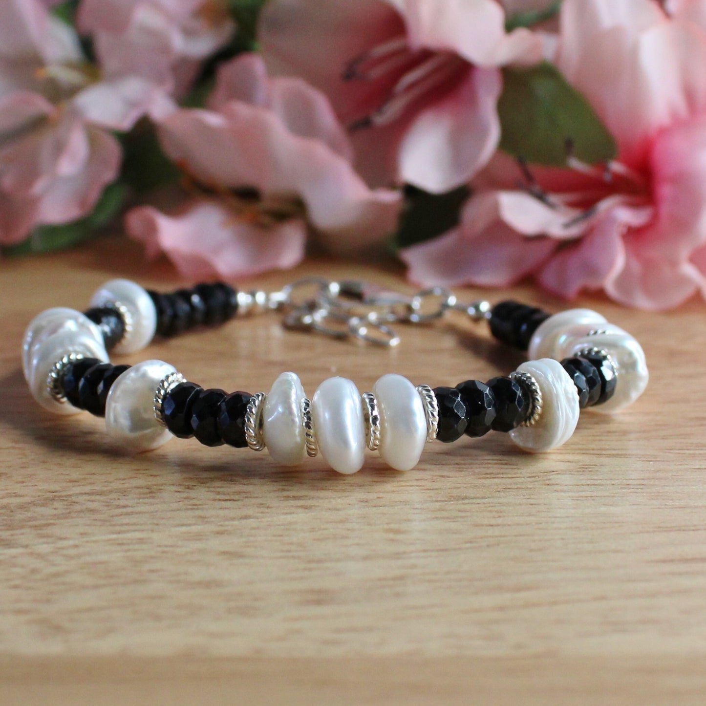 handcrafted black spinel and pearl bracelet. facetted black spinel rondelle gemstone beads. white keishi pearls. sterling silver accent beads, lobster clasp, extender chain 