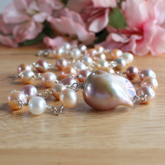 Handcrafted pearl necklace. Peach, mauve, white round pearls. large baroque centre pearl. handwrapped sterling silver wire, lobster clasp