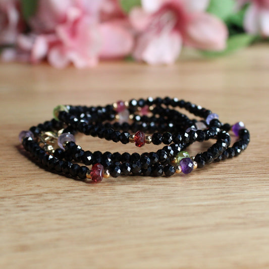 hand crafted black onyx and mixed gemstone necklace. facetted rondelle black onyx. faceted rondelle garnet, amethyst, peridot, lavender amethyst, tanzanite, pink tourmaline gemstones. 