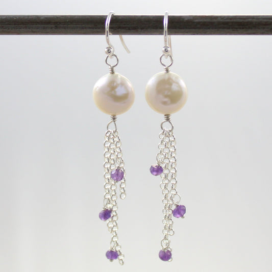 Can you be classic and hip at the same time?  These earrings manage to be. Freshwater Coin Pearls top Amethyst gemstones attached to varying lengths of chain swaying gently as you move. The coin pearls have a luminous lustre with the slightly bumpy surface coin pearls are known for.  The ear wires are sterling silver. 